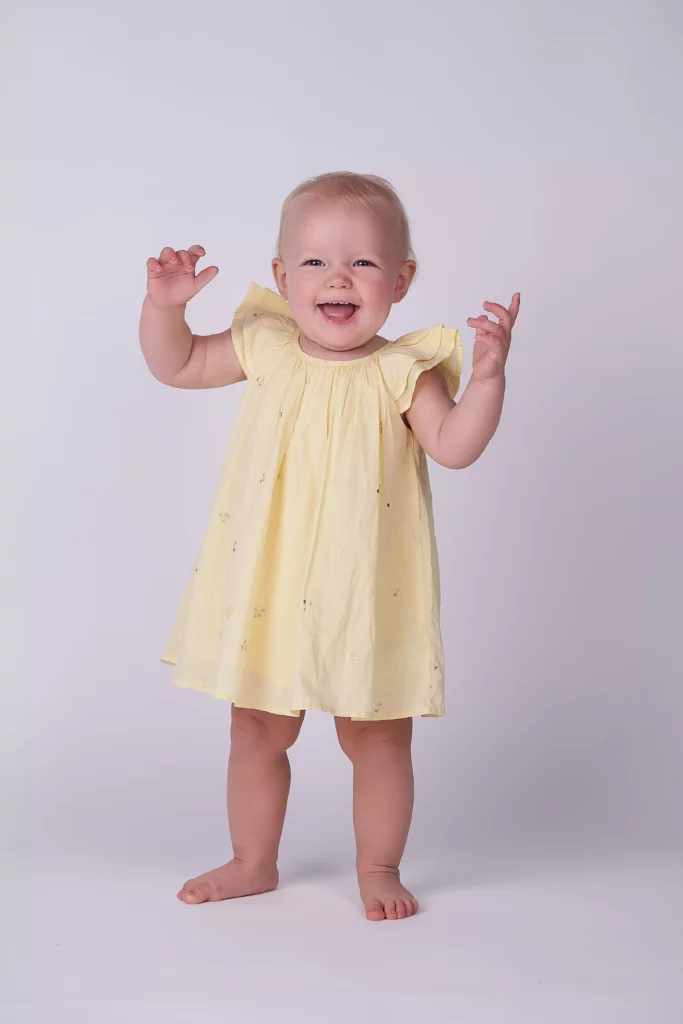 happy girl in yellow dress at the photographer