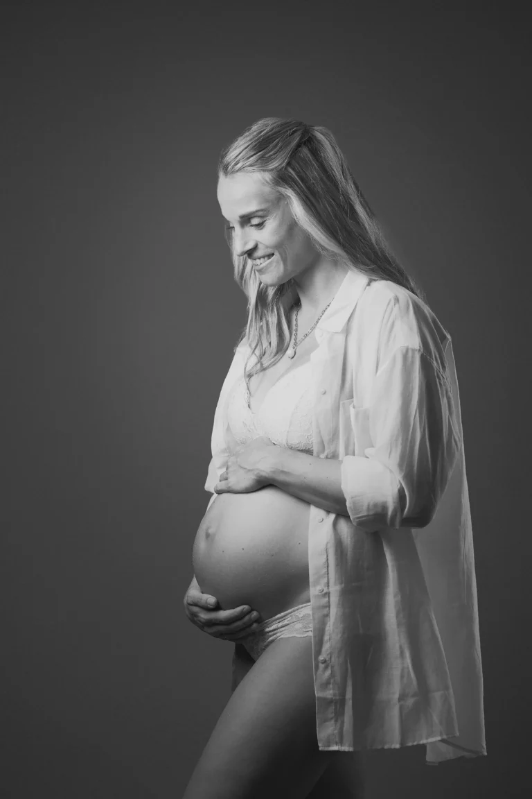 a pregnant woman in white shirt and underwear